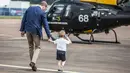Pangeran George berjalan bersama ayahnya, Pangeran William saat mengunjungi Royal International Air Tattoo di RAF Fairford di Gloucestershire, Inggris, (8/7). (REUTERS/Richard Pohle)