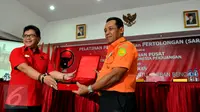 Sekjen PDIP Hasto Kristyanto memberikan cinderamata kepada Kepala Basarnas Bambang Soelistyo usai melepas kader Badan Penanggulangan Bencana Alam (Baguna) untuk latihan bersama Basarnas, Jakarta, Selasa (15/9/2015). (Liputan6.com/Andrian M Tunay)