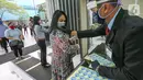 Petugas menempel stiker ke pengunjung usai cek suhu tubuh di Lippo Mall Puri, Jakarta, Senin (15/6/2020). Lippo Malls di wilayah Jakarta kembali beroperasi pada pukul 12.00 – 20.00 WIB dengan menyiapkan protokol kesehatan guna mencegah penyebaran Covid-19. (Liputan6.com/Fery Pradolo)