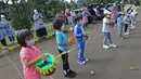 Para siswa TK memainkan miniatur bedug saat mengikuti proses pembelajaran secara Drive in Learning di area parkir Padepokan Pencak Silat Indonesia, Jakarta, Kamis (8/4/2021). Kegiatan ini untuk mengenalkan bulan suci Ramadan kepada anak-anak sedari dini. (Liputan6.com/Herman Zakharia)