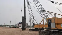 Pekerja menggunakan kendaraan alat berat saat menyelesaikan pemasangan tiang pancang proyek Stadion BMW, Jakarta, Rabu (10/7/2019). Di tengah kasus sengketa lahan dengan PT Buana Permata Hijau, PT Jakarta Propertindo (Jakpro) tetap melanjutkan pembangunan Stadion BMW. (merdeka.com/Iqbal S. Nugroho)