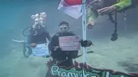 Menparekraf Sandiaga Uno mengibarkan bendera di bawah laut Pulau Pramuka. (dok. Biro Komunikasi Publik Kemenparekraf)