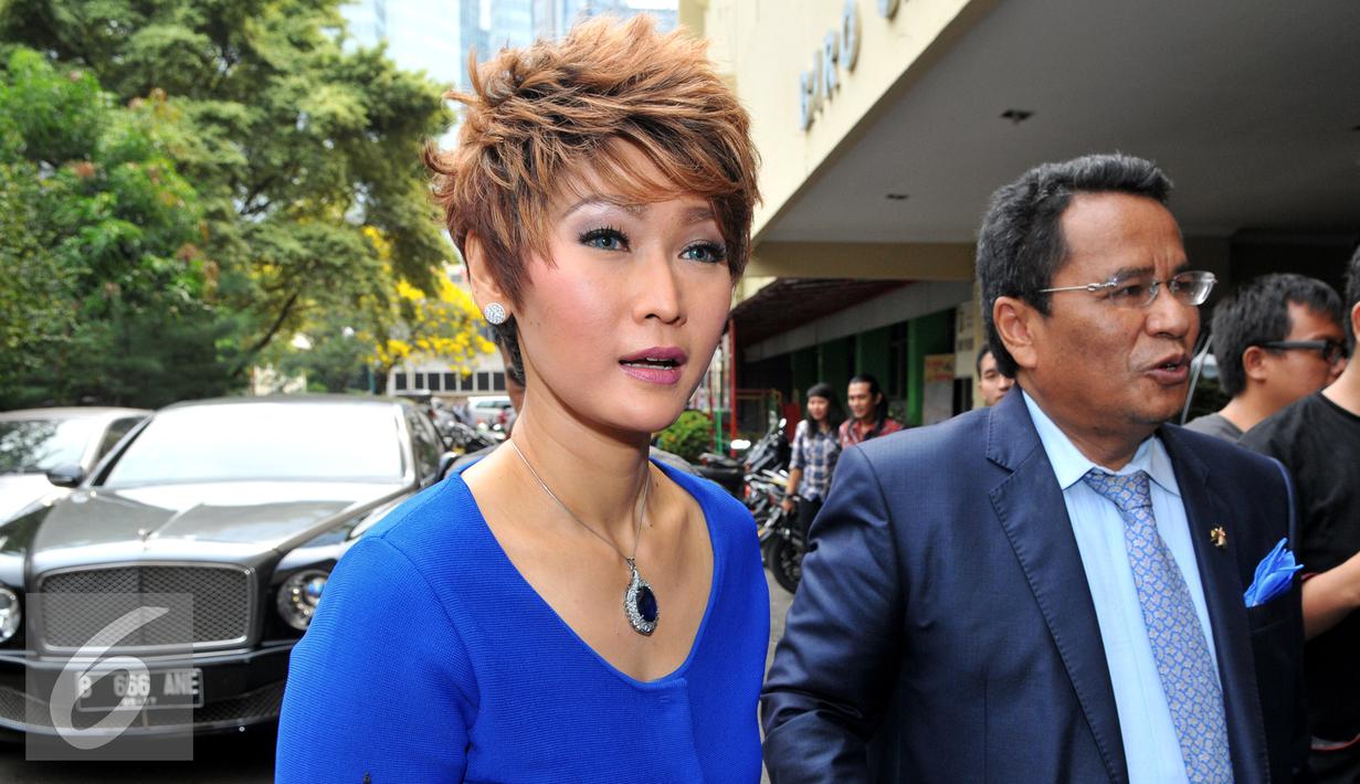 Inul Daratista bersama pengacara Hotman Paris Hutapea berjalan masuk kedalam Polda Metro Jaya, Jakarta, Jumat (13/11). Inul melaporkan pengacara Andar Situmorang terkait pernyataan bahwa inul memiliki anak haram. (Liputan6.com/Faisal R Syam)