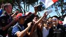 Pebalap Manor F1 Team, Rio Haryanto melayani foto selfie bersama fans sebelum balapan perdana Formula One Australian Grand Prix, Melbourne, Minggu (20/3/2016). (AFP/Paul Crock)