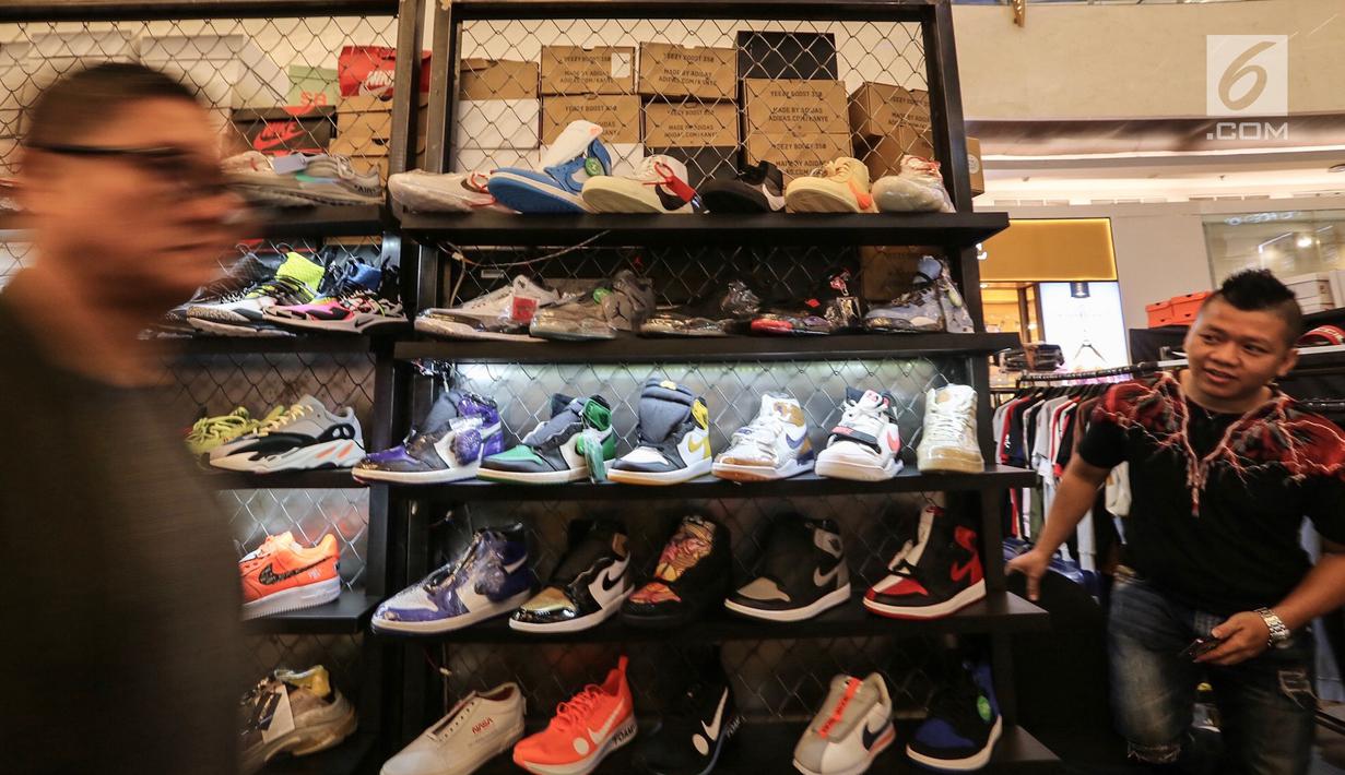 Pengunjung melintas di depan etalase sepatu sneaker pada bazar Sneakerpeak Kemang Quatro di Lippo Mall Kemang, Jakarta, Rabu (20/11). Sneakerpeak Kemang Quatro memberikan inspirasi bagi pecinta dan kolektor sneaker. (Liputan6.com/Fery Pradolo)