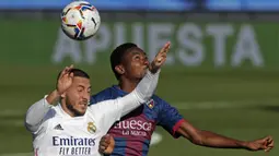 Penyerang Real Madrid, Eden Hazard, berebut bola dengan gelandang Huesca, Kelechi Nwakali, pada laga lanjutan Liga Spanyol di Stadion Alfredo Di Stefano, Sabtu (31/10/2020) malam WIB. Real Madrid menang 4-1 atas Huesca. (AP Photo/Manu Fernandez)