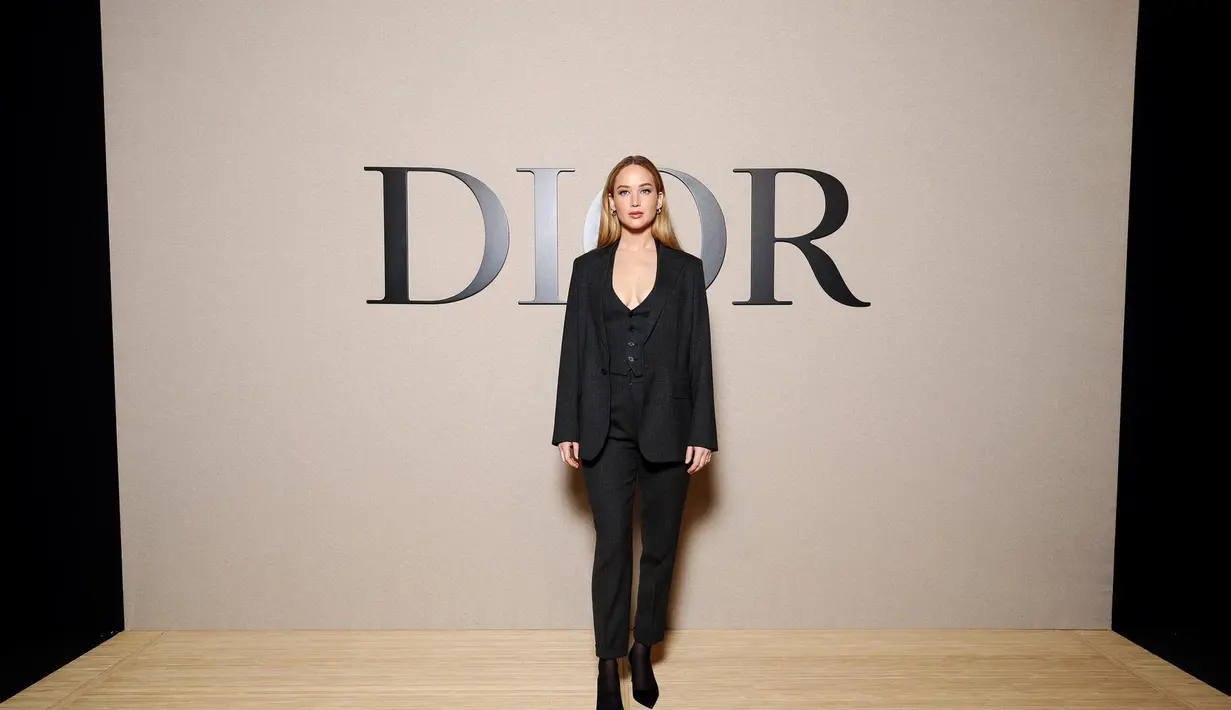 Jennifer Lawrece bergaya androgini dengan setelan jas hitam dan inner vest. Ia kenakan boots sebagai sentuhan di tampilan maskulin [Dior]
