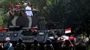 Presiden Joko Widodo saat menaiki Panser Anoa ditemani panglima TNI Jenderal Moeldoko dan Para Kepala Kesatuan jelang upacara pengangkatan dirinya sebagai warga kehormatan pasukan khusus TNI, Kamis (16/4/2015). (Liputan6.com/Yoppy Renato)