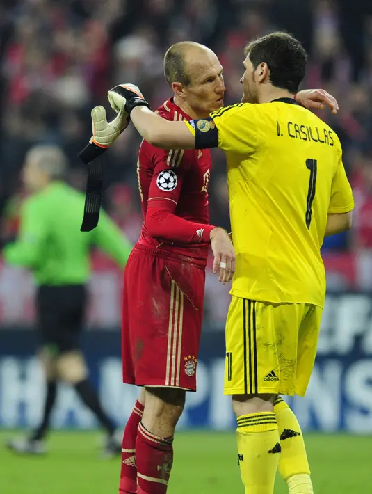 Kiper Real Madrid Iker Casillas (kanan) berpelukan dengan pemain Bayern Munchen Arjen Robben di leg pertama semifinal Liga Champions di Munich, Jerman (17/4/2012). (AFP PHOTO / JAVIER PHOTO Soriano)