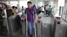 Seorang penyandang disabilitas melintasi "Gate Elektronik" di Stasiun LRT Veldrome, Jakarta, Sabtu (27/4). Kegiatan yang diikuti Jakarta Barrier Free Tourism (JBFT) tersebut untuk mengenalkan kereta Lintas Rel Terpadu (LRT)  lebih dekat kepada masyarakat. (Liputan6.com/Faizal Fanani)