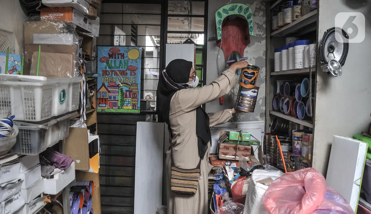 Lani mengambil kaleng-kaleng bekas yang telah dikumpulkan untuk dijadikan produk kerajinan di workshop Kaleng Lani, Tanah Baru, Beji, Depok, Jawa Barat, Minggu (5/6/2022). Perempuan yang sebelumnya berkarir di dunia arsitektur tersebut menggambar berbagai jenis tema yang berkaitan dengan anak-anak dan menjadikan kaleng bekas sebagai tempat pensil, vas bunga, hingga celengan. (merdeka.com/Iqbal S Nugroho)