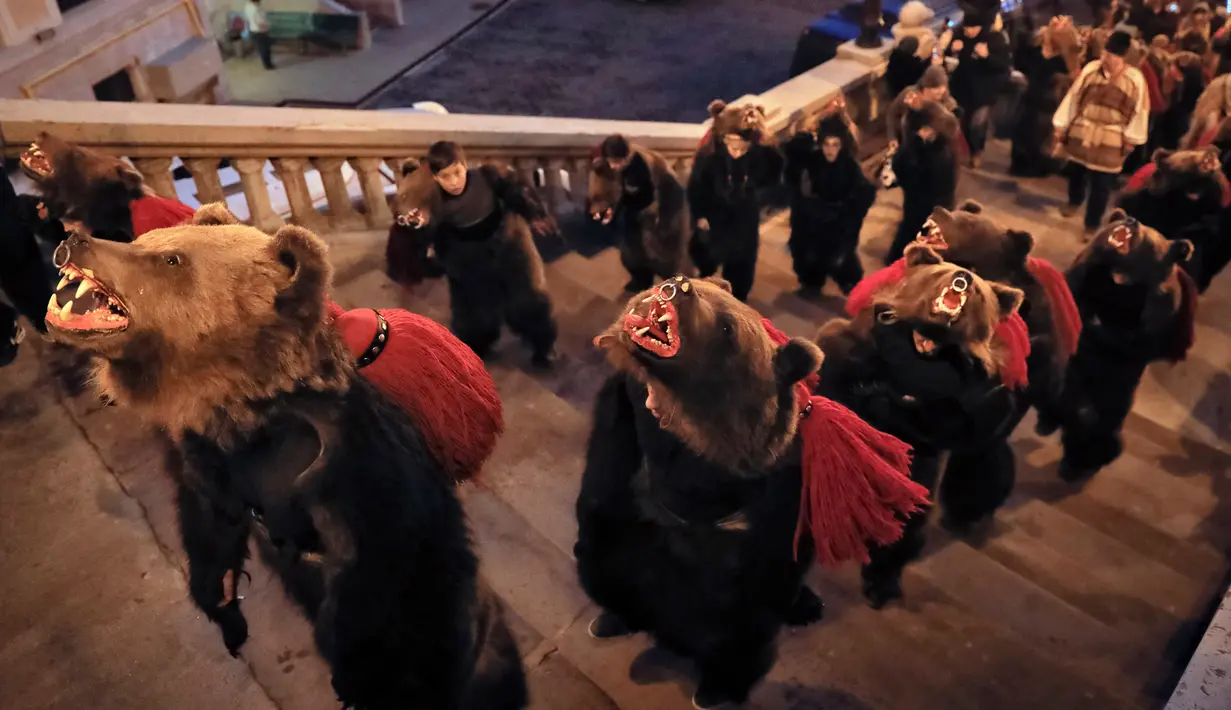Sejumlah remaja dan anak-anak mengenakan kostum beruang bersiap mengikuti ritual tahunan di Piatra Neamt, Rumania Utara (28/12). Dalam tradisi pra-Kristen, beruang dianggap sebagai binatang yang suci. (AP Photo/Vadim Ghirda)