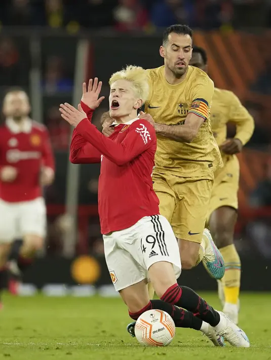 <p>Gelandang Manchester United, Alejandro Garnacho dilanggar pemain Barcelona, Sergio Busquets selama pertandingan leg kedua playoff Liga Europa stadion Old Trafford di Manchester, Inggris, Jumat (24/2/2023). Manchester United menjadi satu dari delapan tim yang melaju ke babak 16 besar. (AP Photo/Dave Thompson)</p>