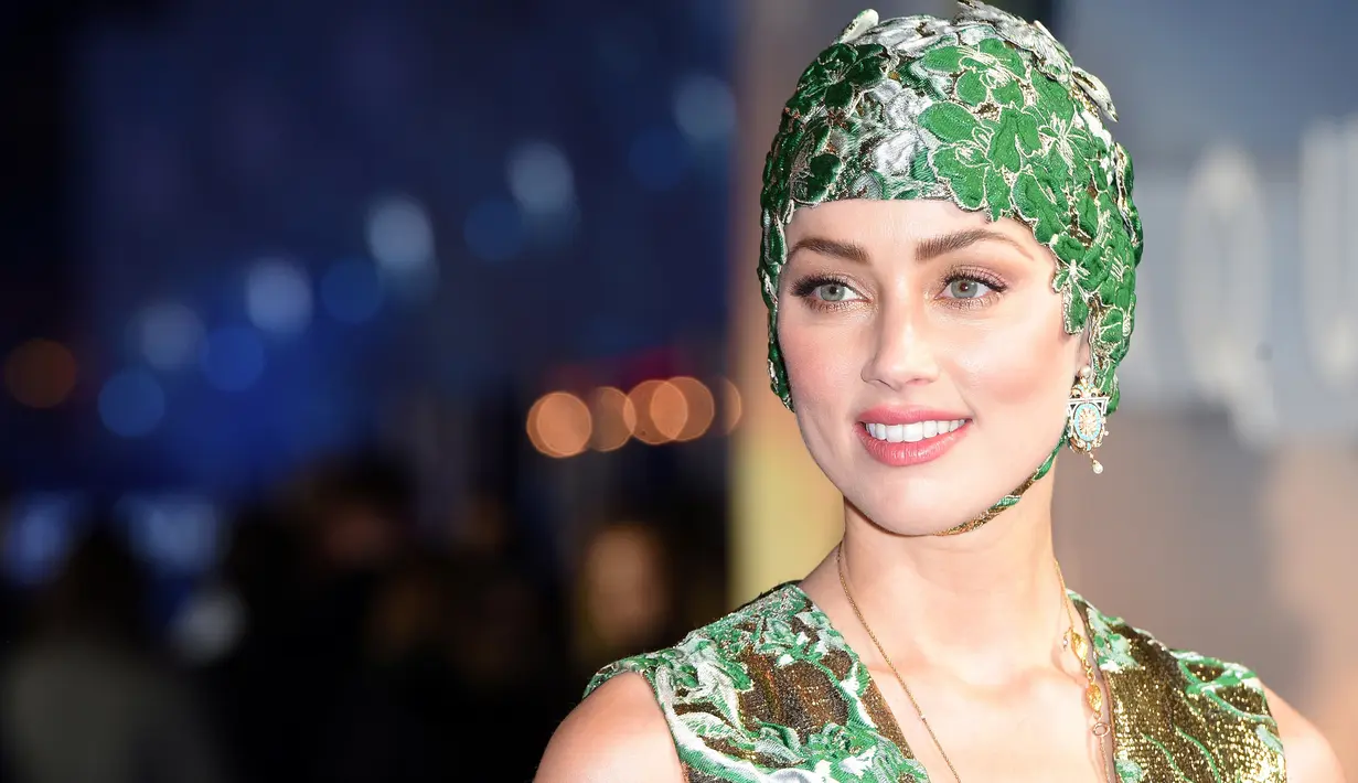 Aktris cantik Amber Heard berpose untuk fotografer setibanya menghadiri premier dunia film 'Aquaman' di London, Senin (26/11). Mantan istri aktor Johnny Depp ini datang dengan dibalut gaun couture dan hiasan kepala. (Anthony HARVEY / AFP)