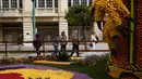 Turis melihat patung yang dibuat dengan lemon dan jeruk selama Festival Lemon ke-88 di Menton, Prancis selatan, Sabtu (19/2/2022). Festival ini berlangsung pada 12-27 Februari dengan tema "Opera dan Tarian". (AP Photo/Daniel Cole)