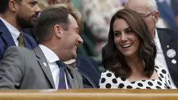 Kate Middleton berbincang dengan penonton lainnya saat menyaksikan pertandingan antara petenis asal Inggris, Andy Murray melawan petenis Rusia, Alexander Bublik pada babak pertama Wimbledon di London, Inggris (3/7). (AFP Photo/Adrian Dennis)