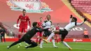 Kiper Liverpool, Alisson Becker (kiri) berusaha menangkap bola dari ancaman striker Fulham, Josh Maja dalam laga lanjutan Liga Inggris 2020/21 di Anfield Stadium, Minggu (7/3/2021). Liverpool kalah 0-1 dari Fulham. (AFP/Paul Ellis/Pool)