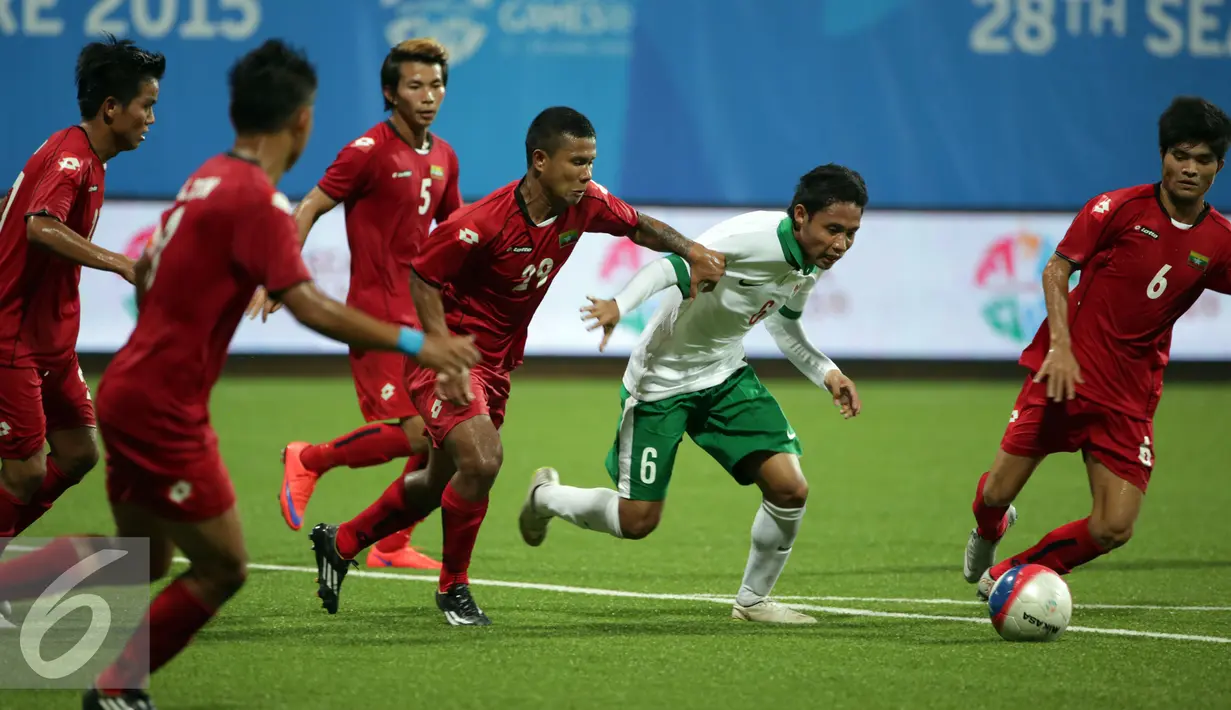 Gelandang timnas Indonesia U-23, Evan Dimas Darmono (kedua kanan) berusaha lolos dari kepungan pemain Myanmar di penyisihan grup A Sea Games 2015 di Stadion Jalan Besar, Singapura, Selasa (2/6/2015). Indonesia kalah 4-2. (Liputan6.com/Helmi Fithriansyah)