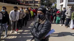 Warga Nepal antre vaksinasi virus corona di sebuah rumah sakit di Kathmandu,  Rabu (19/1/2022). Otoritas juga mewajibkan orang untuk menunjukkan bukti vaksinasi lengkap untuk menggunakan layanan publik mulai minggu ini, yang memicu antrean besar di pusat-pusat vaksin. (AP Photo/Niranjan Shrestha)