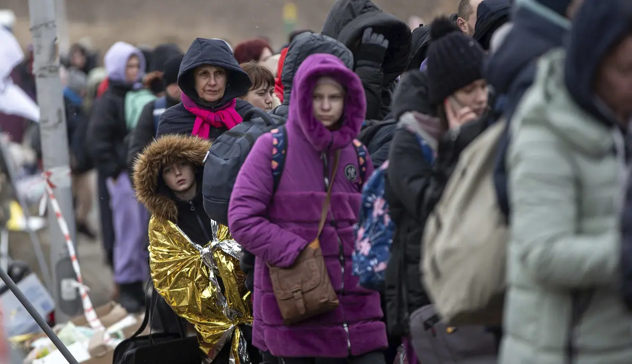 Seorang anak terbungkus selimut termal antre menunggu untuk naik bus setelah melarikan diri dari Ukraina dan tiba di perbatasan di Medyka, Polandia, Senin (7/3/2022). Hampir 2 juta orang melarikan diri dari Ukraina sejak invasi Rusia dengan jumlah itu meningkat setiap hari. (AP Photo/Visar Kryeziu)