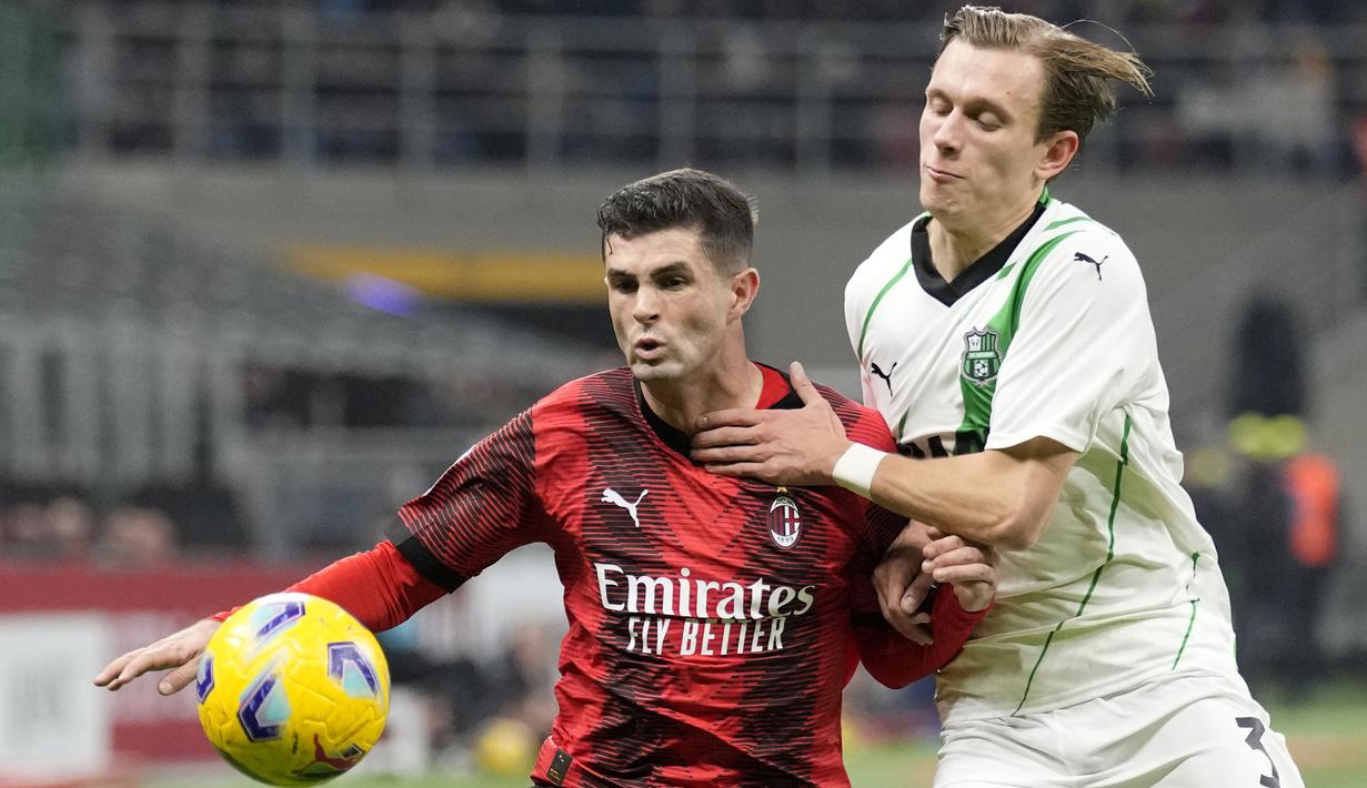 Striker AC Milan, Christian Pulisic (kiri) berebut bola dengan bek Sassuolo, Marcus Pedersen pada laga pekan ke-18 Serie A Liga Italia 2023/2024 di San Siro Stadium, Milan, Sabtu (30/12/2023) malam waktu setempat. (AP Photo/Antonio Calanni)