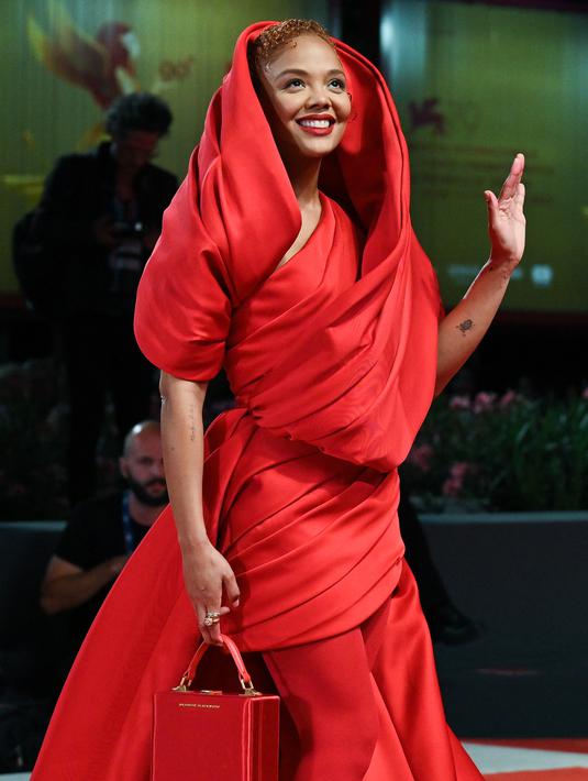 Aktris AS, Tessa Thompson tiba untuk pemutaran film "Bardo, False Chronicle of a Handful of Truths" selama Venice Film Festival ke-79 di Lido di Venezia di Venesia, Italia, Kamis (1/9/2022). Tessa Thompson memamerkan tubuh langsingnya dalam balutan gaun merah dramatis dengan detail ruched. (Tiziana FABI / AFP)