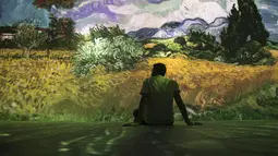 Seorang tamu duduk di pameran multimedia Van Gogh Live 8K yang menampilkan proyeksi lukisan seniman Belanda Vincent Willem van Gogh, pada pembukaan pameran untuk media dan tamu, di Rio de Janeiro, Brasil, Rabu (27/7/2022). (AP Photo / Bruna Prado)