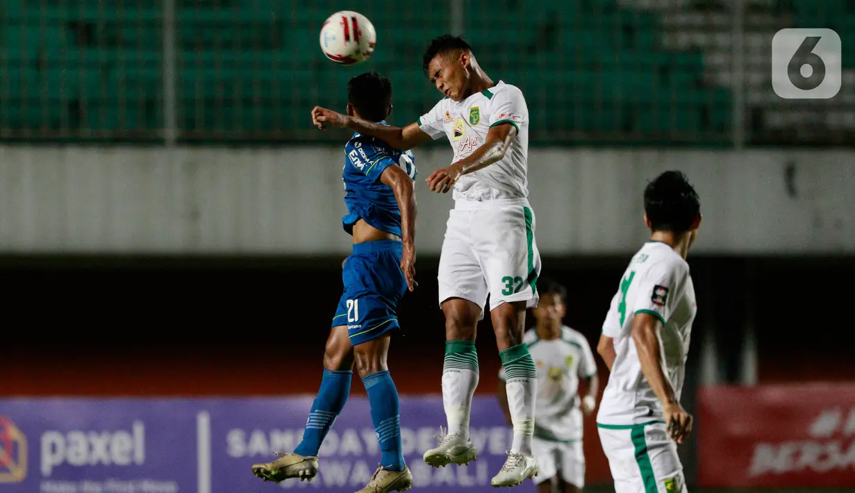 Pemain Persib Bandung, Frets Butuan (kiri) duel udara dengan bek Persebaya Surabaya, Rizky Ridho, pada laga perempat final Piala Menpora 2021 di Stadion Maguwoharjo, Sleman, Minggu (11/4/2021). (Bola.com/M Iqbal Ichsan)