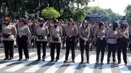 Aparat Polri wanita berjaga saat Hari Buruh Sedunia di depan Istana Negara, Jakarta, Selasa (1/5). Para buruh berbondong-bondong datang menuju Istana Kepresidenan membawa bendera dan atribut masing-masing serikat kerjanya. (Liputan6.com/Johan Tallo)