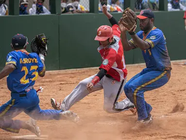 M. Rizki dari DKI Jakarta sliding di home base pada pertandingan kedua babak penyisihan softball putra PON XX Papua antara DKI Jakarta vs Papua Barat di Lapangan Softball Uncen, Kota Jayapura, Rabu (22/09/2021). (Foto : PB PON XX PAPUA/Robertus Pudyanto)