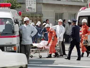Petugas medis membawa korban ke ambulans setelah serangan gas sarin oleh sekte kiamat Aum Shinrikyo di stasiun kereta bawah tanah Tsukiji, Tokyo, Jepang, 20 Maret 1995. Serangan tersebut menewaskan 13 orang dan melukai ribuan lainnya. (JIJI PRESS/AFP)