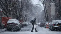 Seorang pria berjalan saat badai salju di Brooklyn di New York City (7/3). Badai salju kedua yang melanda New York dalam waktu seminggu ini diperkirakan akan membawa angin kencang. (Drew Angerer/Getty Images/AFP)