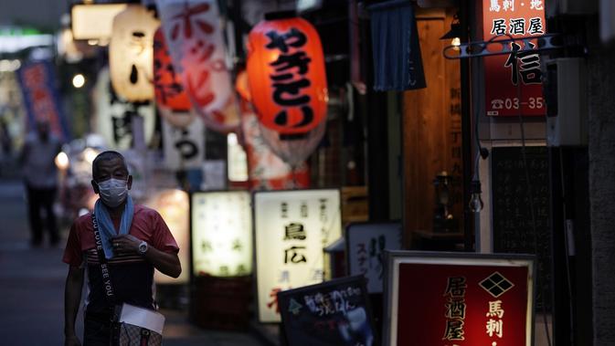 Seorang pria yang memakai masker untuk membantu mencegah penyebaran virus corona berjalan di sebuah jalan bar di Tokyo, Kamis (10/9/2020). Ibukota Jepang mengonfirmasi lebih dari 270 kasus virus korona pada hari Kamis. (AP Photo / Eugene Hoshiko)