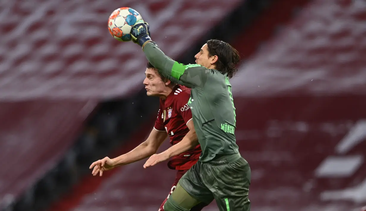 Kiper Borussia Monchengladbach, Yann Sommer melakukan penyelamatan di depan bek Bayern Munchen Benjamin Pavard pada laga pekan ke-18 Bundesliga di Allianz Arena, Sabtu (8/1/2022) dini hari WIB. Bayern Munchen dipermalukan di kandang sendiri 1-2. (CHRISTOF STACHE/AFP)