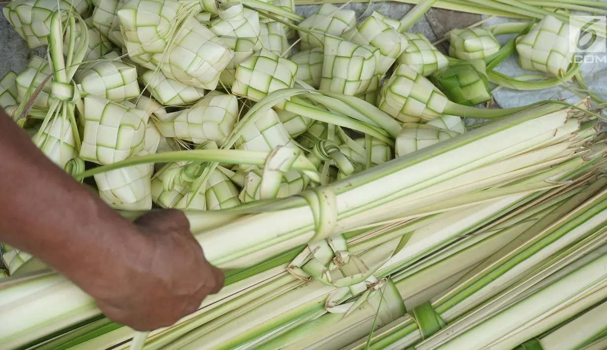 Pedagang membuat kulit ketupat dari daun kelapa di kawasan Bintaro, Jakarta, Sabtu (10/8/2019). Menjelang Idul Adha, para pedagang menjual kulit ketupat dengan harga sekitar Rp 8 ribu per sepuluh buah tergantung ukuran. (Liputan6.com/Herman Zakharia)