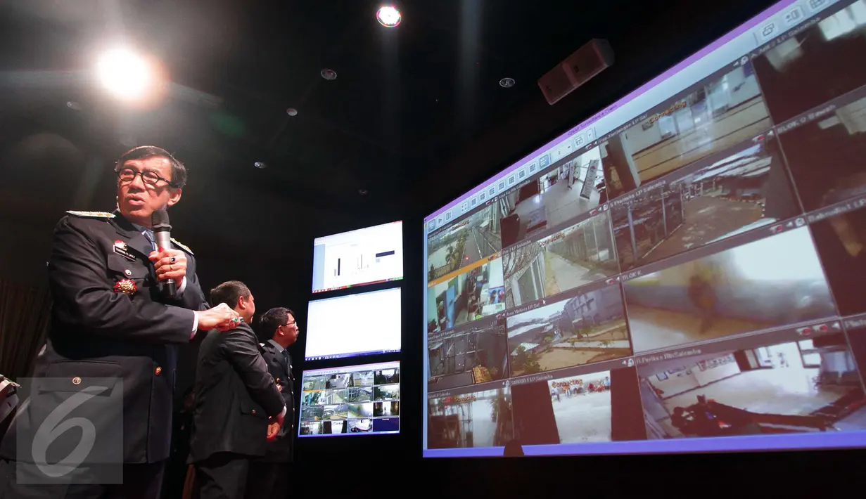 Menkumham Yasonna H Laoly (kiri) melihat layar yang menunjukkan tayangan langsung kamera CCTV di sejumlah Lapas di Control Room Kami Pasti di Gedung Kemenkumham, Jakarta, Jumat (30/10). (Liputan6.com/Helmi Afandi)
