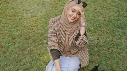 Mengenakan hijab cokelat, Cita Citata menikmati suasana di luar rumah. Duduk di rerumputan membuatnya bahagia. (Foto: Instagram/@cita_citata)