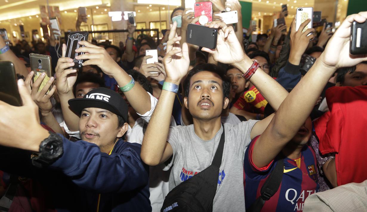 Suporter menyambut kedatangan legenda Barcelona, Carles Puyol, saat jumpa fans di Jakarta, Senin (11/3). Jumpa fans ini dalam rangka UEFA Champions League Trophy Tour di Indonesia. (Bola.com/Vitalis Yogi Trisna)