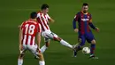 Gelandang Athletic Bilbao, Unai Vencedor (tengah) berebut bola dengan penyerang Barcelona Lionel Messi pada pekan ke-21 Liga Spanyol 2020/21 di Stadion Camp Nou, Senin (1/2/2021) dini hari WIB. Barcelona sukses mengalahkan Athletic Bilbao dengan skor tipis 2-1. (AP Photo/Joan Monfort)