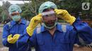 Petugas memasang kacamata dan masker sebelum menyemprotkan cairan disinfektan di area Museum Fauna Indonesia Komodo dan Taman Reptilia, TMII Jakarta, Rabu (18/3/2020). Pengelola TMII secara bertahap melakukan tindakan disinfeksi di setiap lokasi wisata dan anjungan. (Liputan6.com/Fery Pradolo)