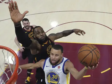 Aksi pemain Warriors, Stephen Curry melakukan tembakan saat diadang pemain Cavaliers, LeBron James pada gim ketiga final NBA basketball di Quicken Loans Arena, (6/6/2018). Warriors kalahkan Cavaliers 110-102. (Gregory Shamus/Pool via AP)