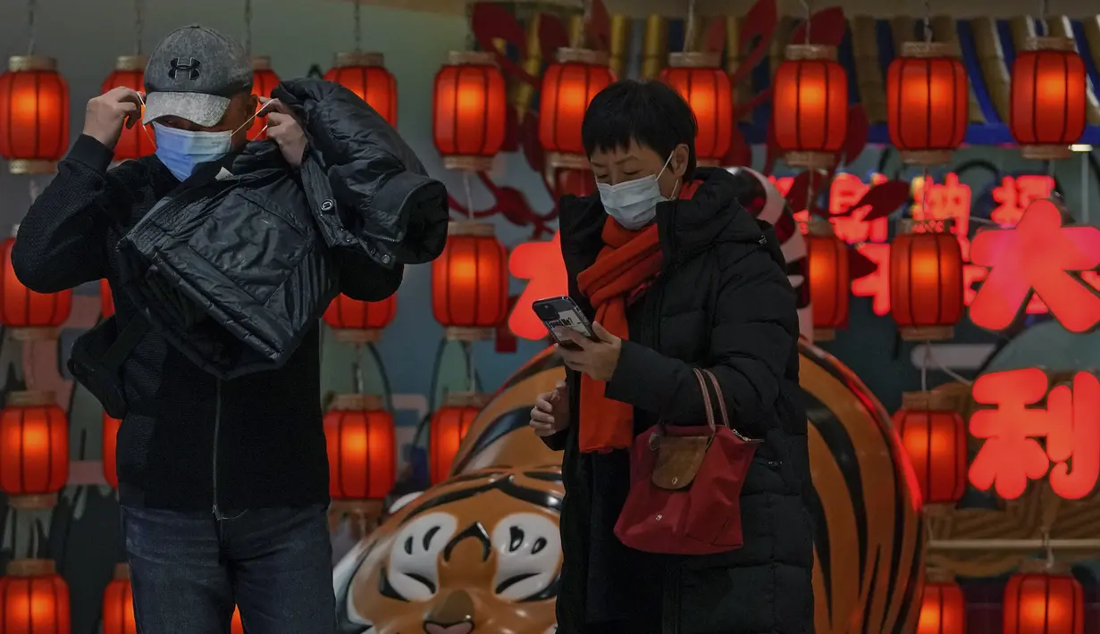 Seorang pria mengenakan masker di sebuah pusat perbelanjaan di Beijing, Minggu (9/1/2022). Tianjin memulai pengujian massal terhadap 14 juta penduduknya setelah sekelompok anak-anak dan orang dewasa dinyatakan positif COVID-19, beberapa dengan varian omicron. (AP Photo/Andy Wong)