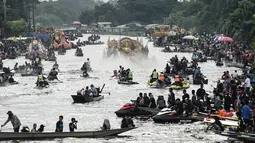 Sejumlah perahu mengelilingi patung Buddha terapung saat festival Rab Bua di Samut Prakan (4/10). Ratusan perahu kecil ini turun ke sungai ikut memeriahkan festival Rab Bua. (AFP Photo/Lillian Suwanrumpha)