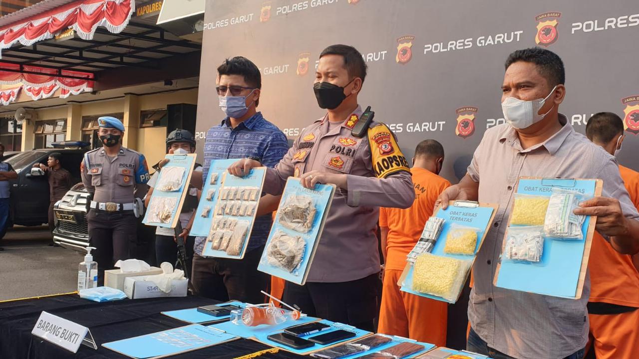 Kapolres Garut AKPB Wirdhanto Hadicaksono, menunjukan barang bukti tembakau sintetik dan narkotika lainnya dalam rilis kasus di Mapolres Garut, Selasa (2/8/2022). (Liputan6.com/Jayadi Supriadin)