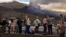 Wisatawan melihat dan berswafoto dengan latar gunung berapi yang meletus di Canary, Pulau La Palma, Spanyol, 26 Oktober 2021. Para pejabat mengatakan gunung berapi yang meletus selama lima minggu terakhir di Pulau La Palma lebih aktif dari sebelumnya. (AP Photo/Emilio Morenatti)