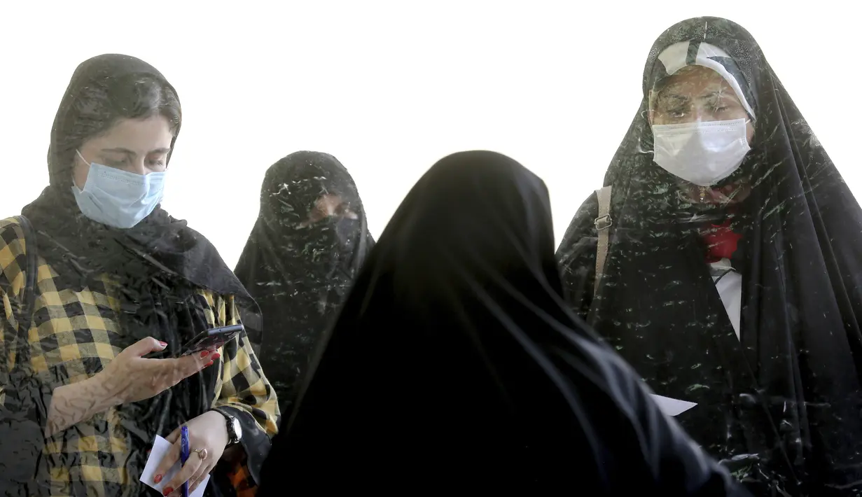 Para pemilih mendaftar untuk memberikan suara mereka selama pemilihan presiden di sebuah tempat pemungutan suara di Teheran, Iran, Jumat (18/6/2021). Warga Iran mulai memberikan suaranya dalam pemilihan presiden. (AP Photo/Ebrahim Noroozi)