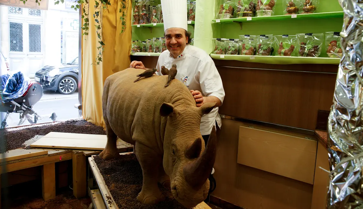 Pembuat cokelat Prancis, Eric Thevenot berfoto dengan karyanya cokelat berbentuk badak di Nogent-sur-Marne, Prancis (8/4). Sebelumnya penyusup telah membunuh badak jantan yang terancam punah di kebun binatang Thoiry. (AFP/Geoffroy Van Der Hasselt)