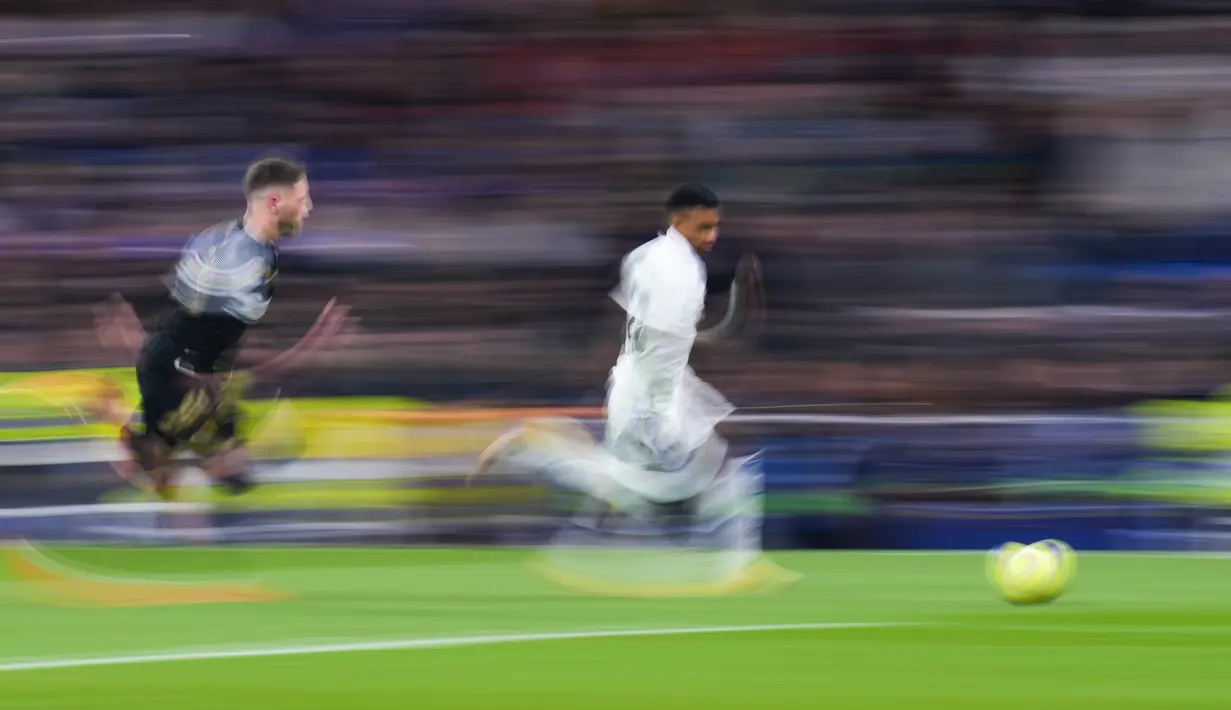 Penyerang Real Madrid, Rodrygo menggiring bola dari kejaran pemain Elche, Jose Angel Carmona selama pertandingan lanjutan La Liga Spanyol di stadion Santiago Bernabeu di Madrid, Spanyol, Kamis (16/2/2023). Kemenangan Real Madrid atas tim juru kunci klasemen Liga Spanyol menambah raihan mereka menjadi 48 poin dari 21 laga. (AP Photo/Manu Fernandez)