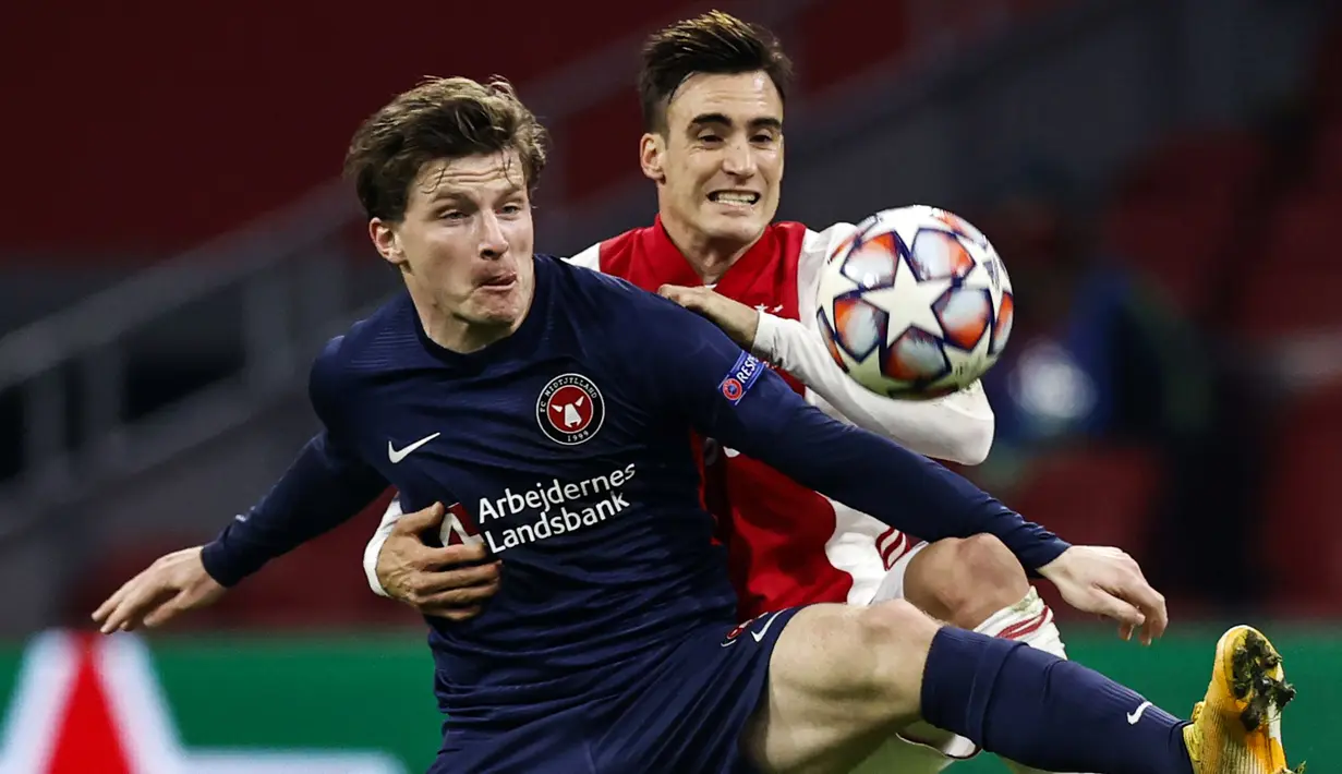 Striker FC Midtjylland, Anders Dreyer (kiri), berebut bola dengan bek Ajax, Nicolas Tagliafico dalam laga lanjutan Liga Champions 2020/21 Grup D melawan FC Midtjylland di Johan Cruijff Stadium, Amsterdam, Kamis (26/11/2020). FC Midtjylland kalah 1-3 dari Ajax. (AFP/Maurice Van Steen/ANP)