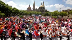 Pasangan menari mengikuti irama musik tradisional mariachi untuk memecahkan Rekor Dunia Guinness di Guadalajara, Meksiko pada 24 Agustus 2019. Sebanyak 882 orang menari dengan kostum tradisional dalam upaya memecahkan rekor dunia untuk kategori tarian rakyat terbesar. (ULISES RUIZ/AFP)